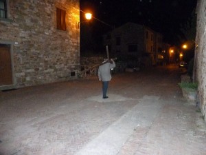 La Croix portée dans la magie nocturne d'une rue évoquant le Moyen Âge