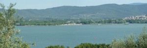Vue panoramique du resserrement progressif du passage entre les hautes collines boisées et la rive du lac
