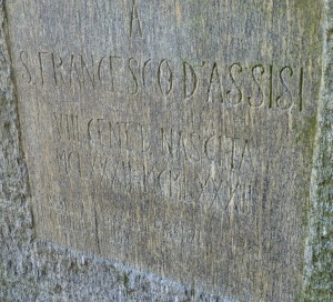 Inscription sur le socle de la statue de saint François