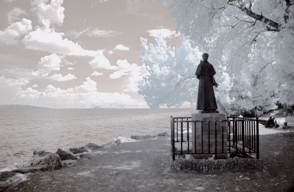 Traitement visant à évoquer l'aura surnaturelle qui nimbe saint François.Lieu du débarquement de saint François à l'Isola Maggiore en 1211.